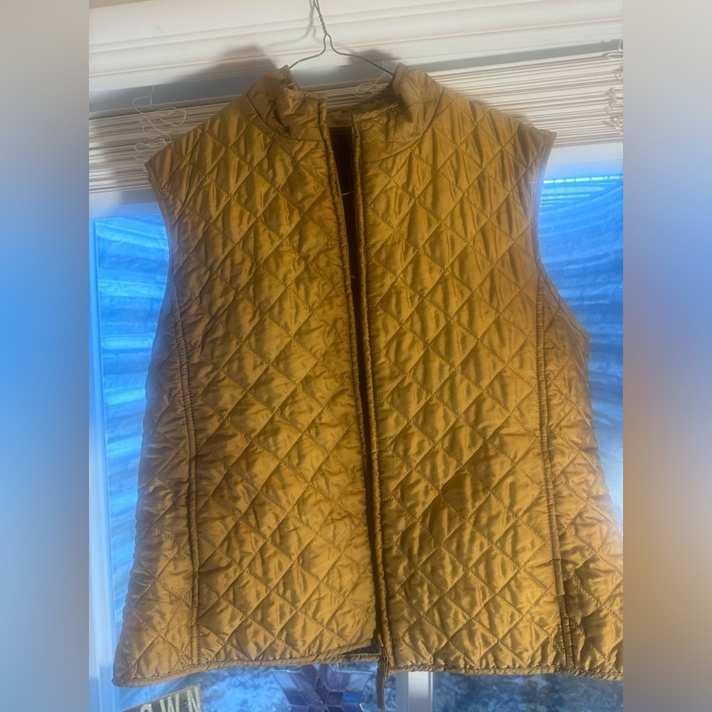 A fitted puff vest, gold in color. Very vibrant.